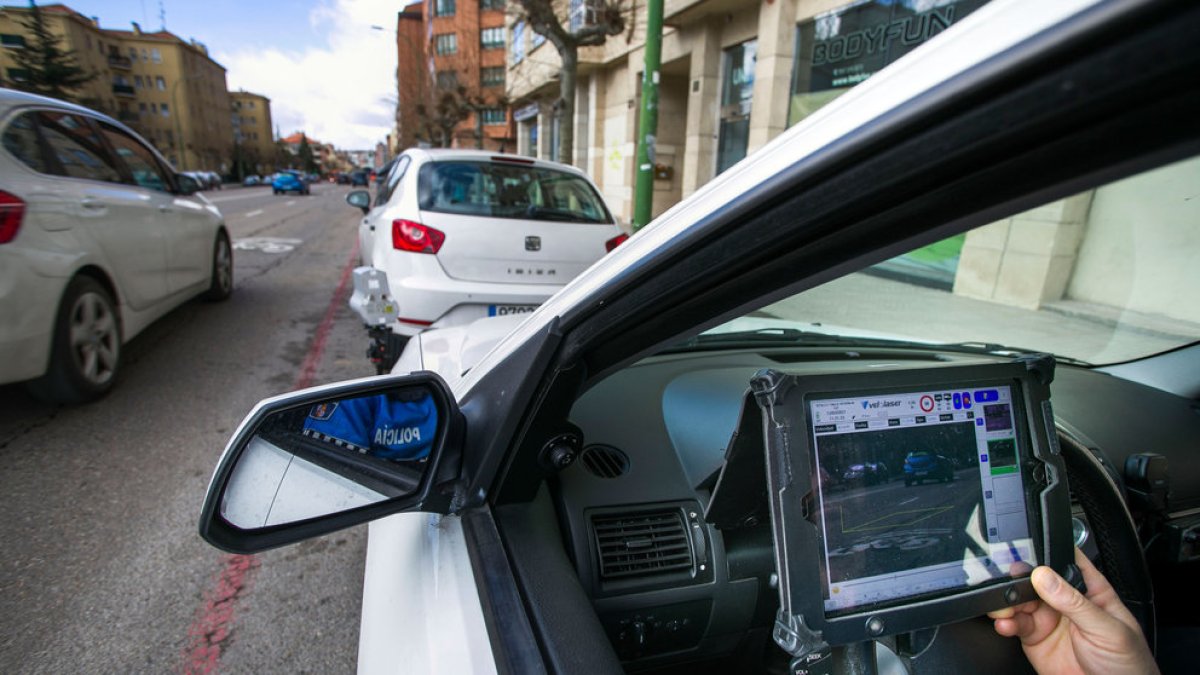Un agente sostiene la pantalla del radar móvil durante un operativo de vigilancia de la velocidad en las calles de Burgos. TOMÁS ALONSO