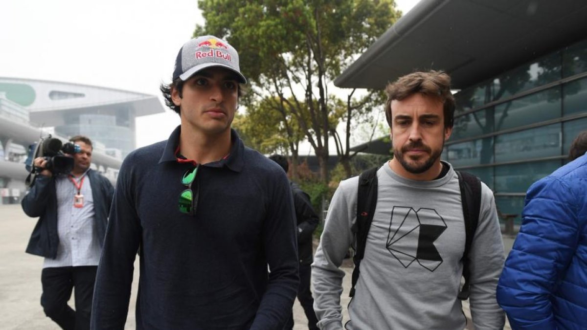 Fernando Alonso, en compañía de Carlos Sainz, por los exteriores del circuito de Shangai.-GREG BAKER / AFP