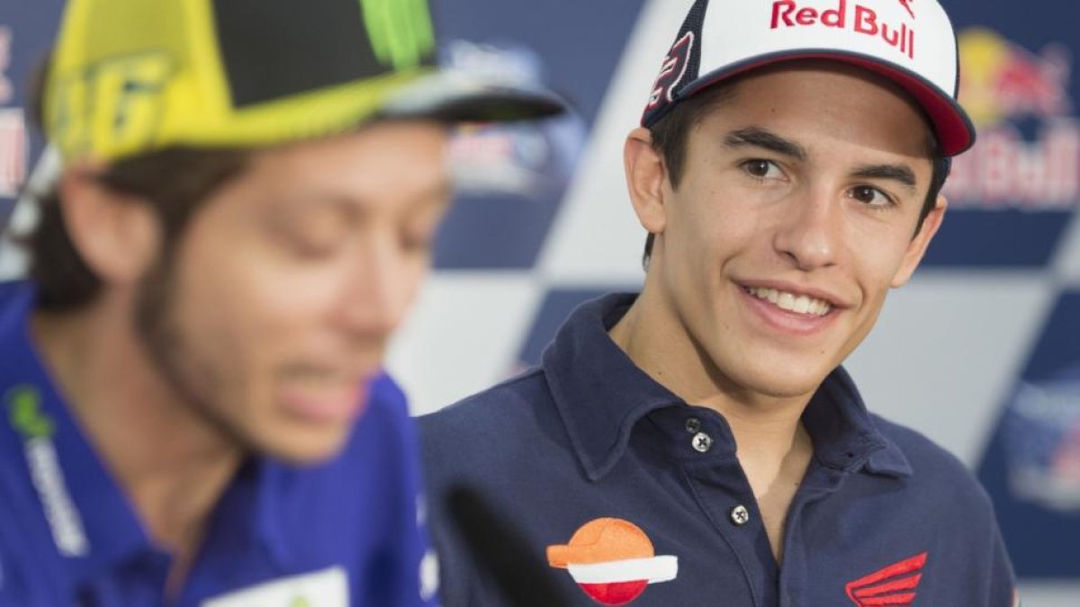 Marc Márquez mira y sonríe ante las palabras de Valentino Rossi.-MIRCO LAZZARI