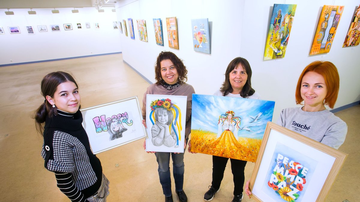 Posan con sus obras Sofía Pavón, Anzhelika Svirska y Olesia Kotelevska. Les acompaña Virginia, una voluntaria del equipo que porta el cuadro de Olena Hontar. TOMAS ALONSO