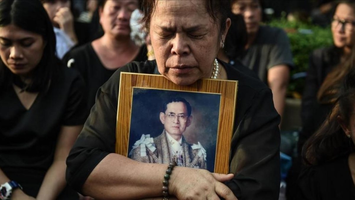Una mujer llora la muerte del rey Bhumibol de Tailandia frente al Gran Palacio de Bangkok.-AFP / LILLIAN SUWANRUMPHA