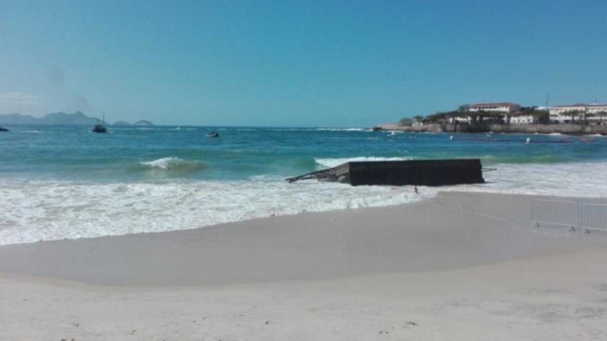 La plataforma desde la que debían saltar los nadadores de aguas abiertas, destrozada por las olas y varada en Copacabana.-KIKO HERVÁS