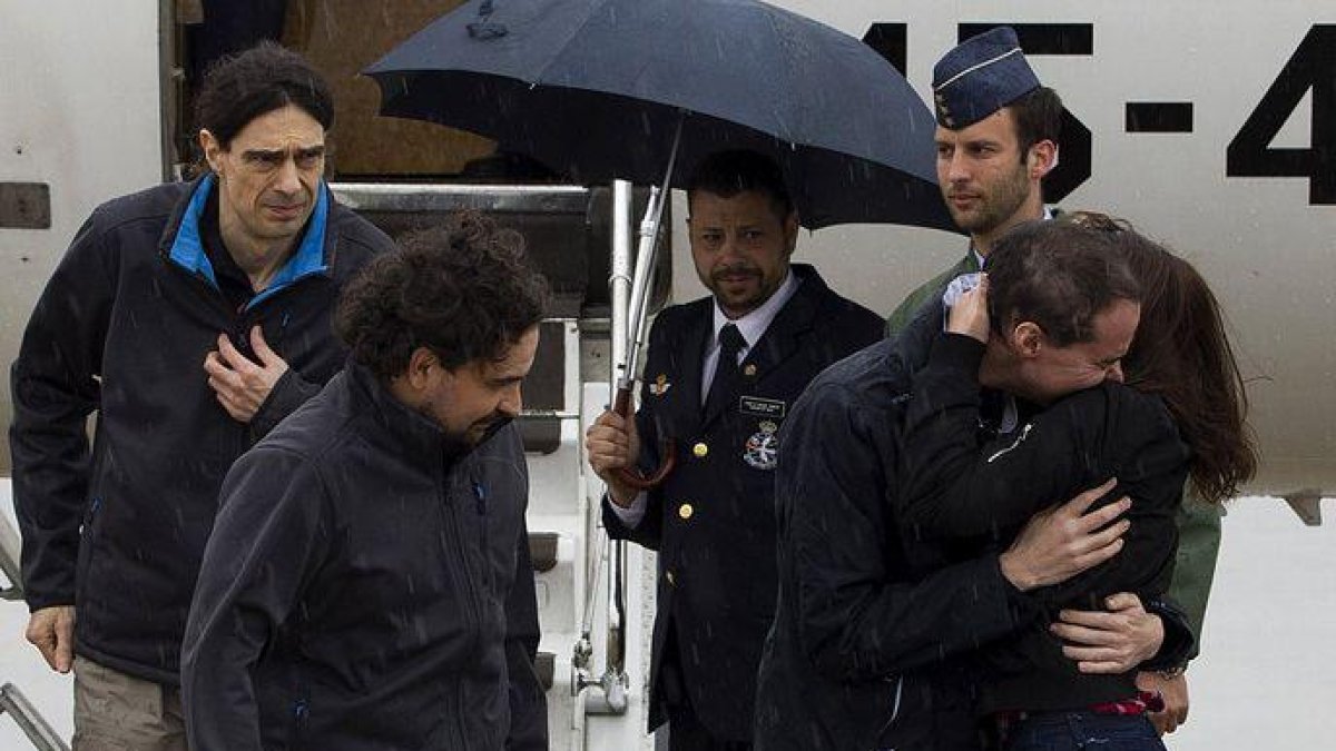 Ángel Satre, en el centro, José Manuel López, a la izquierda,  y Antonio Pampliega, a la derecha, abrazado a un familiar.-EFE/ DIEGO CRESPO