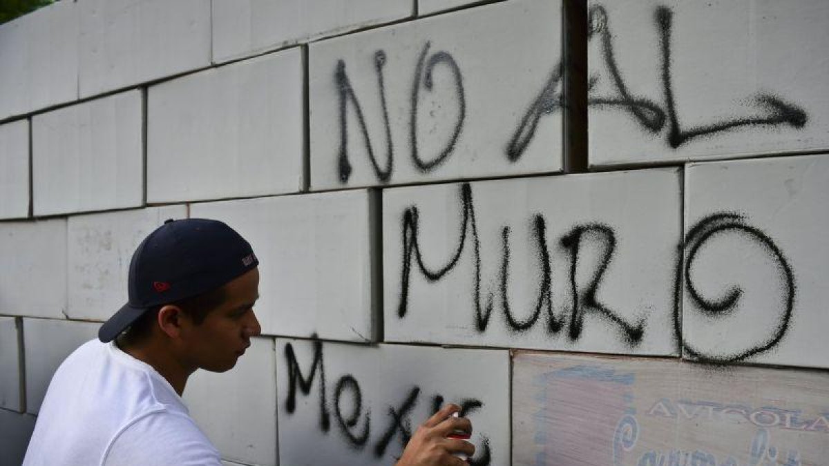 Pintadas sobre un muro hecho con cajas de cartón en contra del muro, en México .-AFP / RONALDO SCHEMIDT