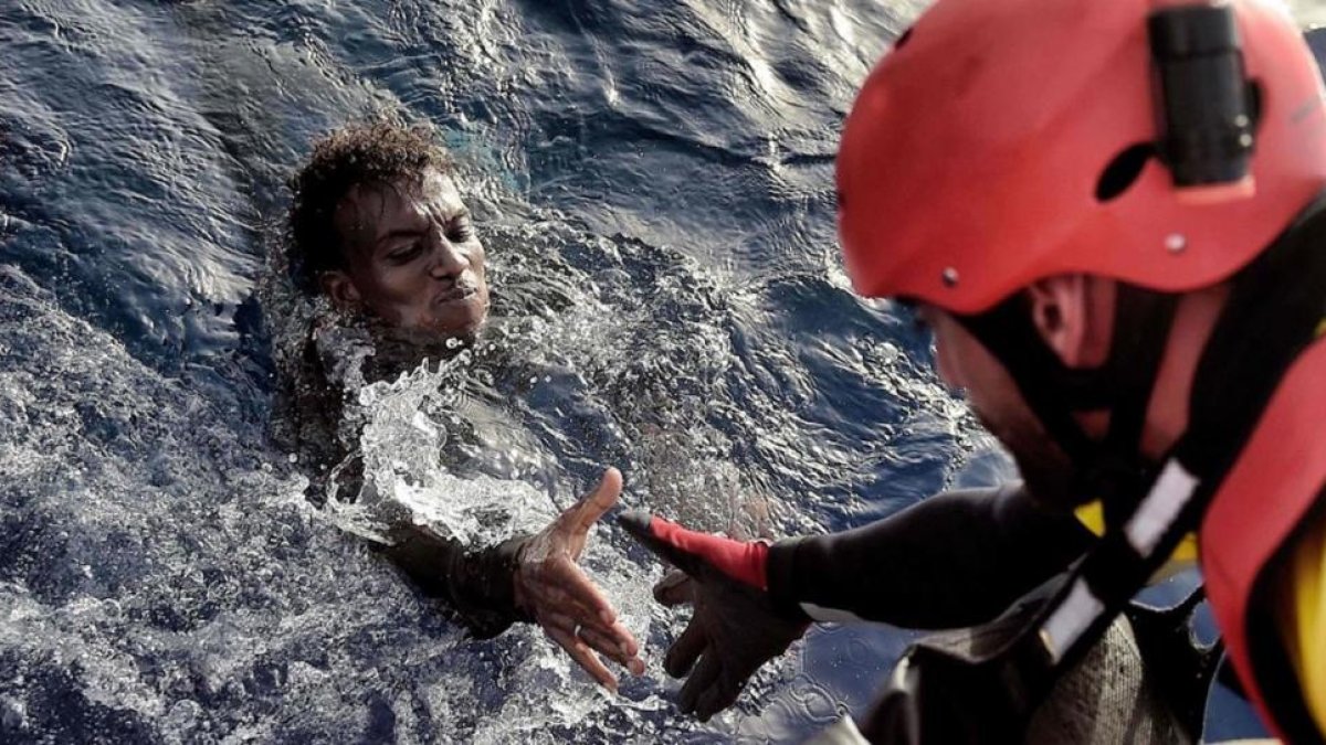 Un miembro de la oenegé Proactiva Open Arms rescata a un inmigrante en el Mediterráneo, frente a la costa libiam en octubre del 2016.-ARIS MESSINIS
