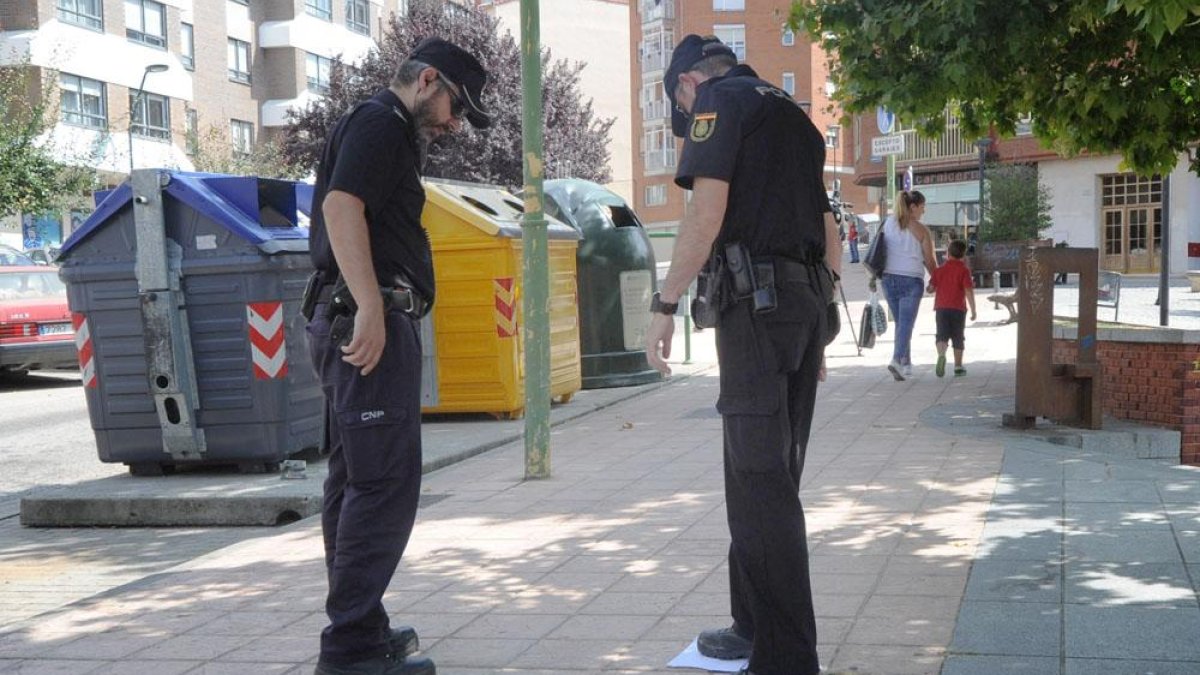 Dos agentes de Policía observan el lugar donde se produjo la pelea.-ISRAEL L. MURILLO