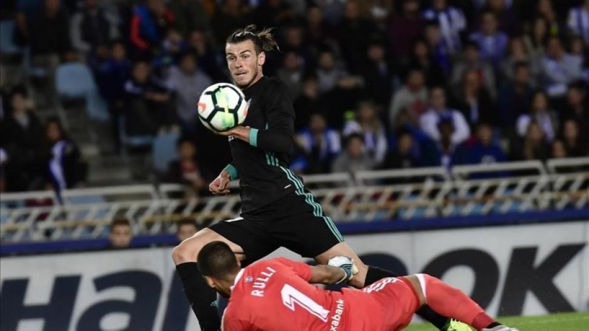 Bale pica el balón ante Rulli para marcar el tercer gol del Madrid en Anoeta.-ÁLVARO BARRIENTOS / AP