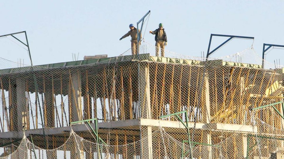 Dos obreros realizan su trabajo en la construcción de un edificio.-ISRAEL L. MURILLO