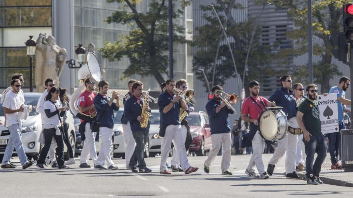 Miembros de la charangaextraperlo cruzan la calle camino del centro histórico.-SANTI OTERO