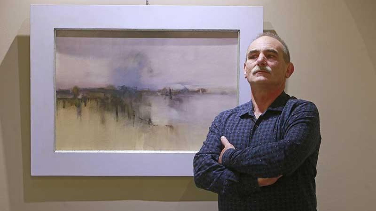 Rafa Mediavilla, junto a una de las obras en las que evoca su paisaje de la infancia en tierras del Arlanza.-Raúl Ochoa