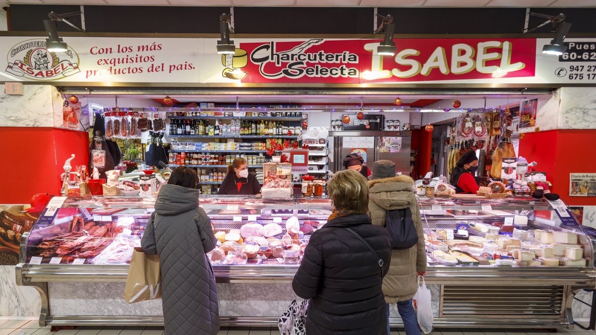 Varios clientes esperan su turno en el puesto de Charcutería selecta Isabel, en el Mercado Norte. SANTI OTERO