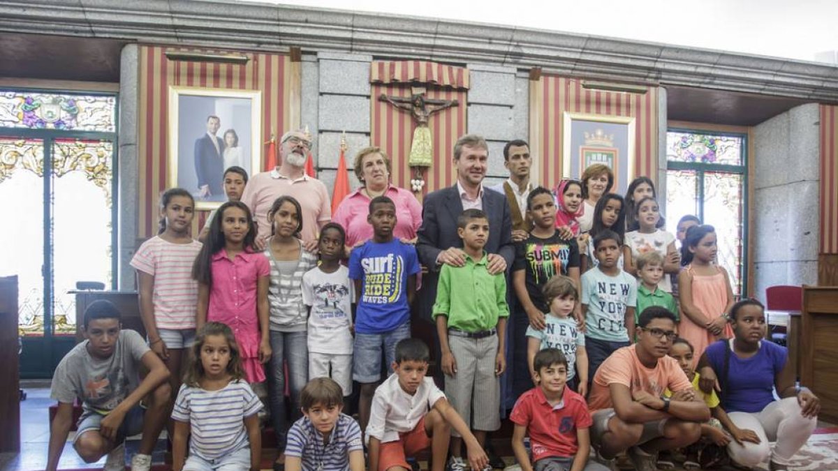 Foto de familia de los nños saharauis con el alcalde, Javier Lacalle y la concejala, Ana Lopidana, el presidente de la asociación, Antonio Ibáñez, y Abdi, en el salón de Plenos.-SANTI OTERO