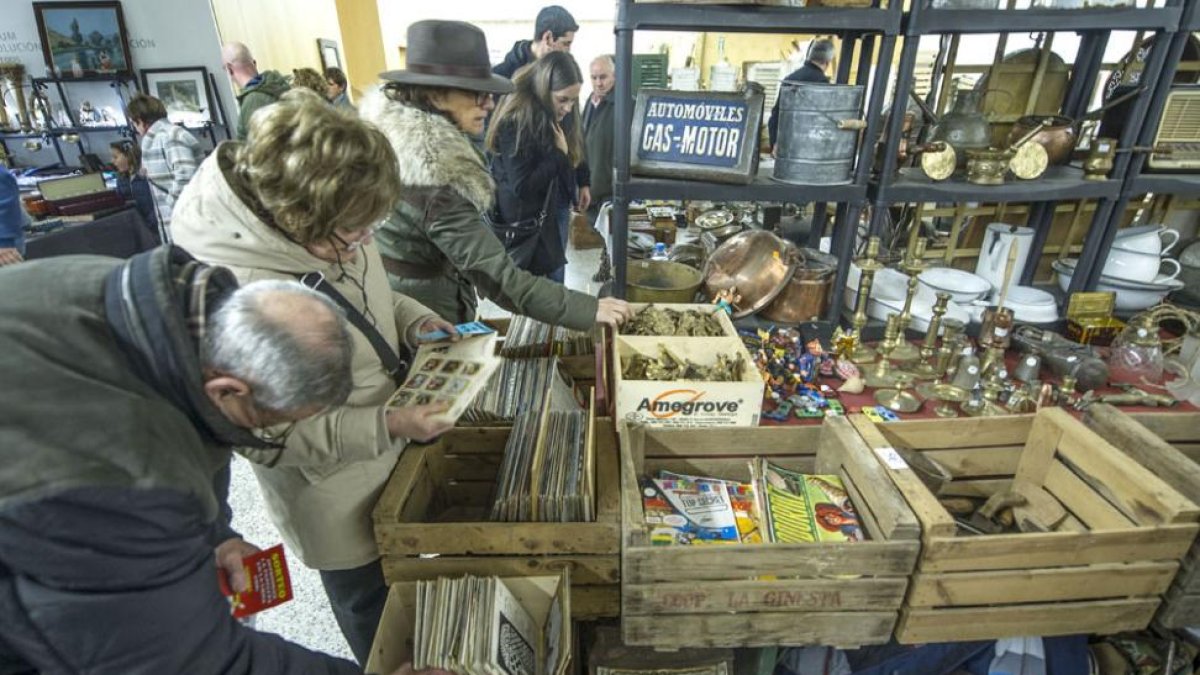 Varias personas miran discos de vinilo en uno de los puestos de la feria.-ISRAEL L. MURILLO