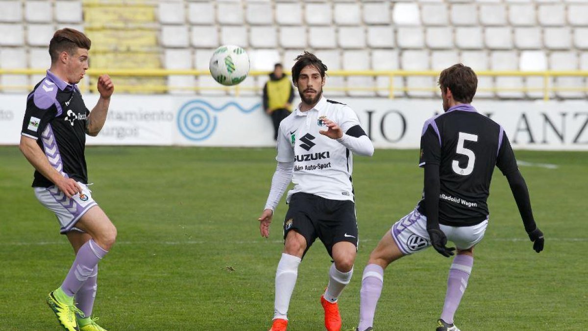 Andrés golpea el balón en presencia de dos jugadores del Real Valladolid B.-SANTI OTERO