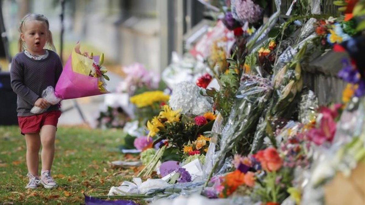 Una niña pone flores en el memorial de recuerdo del atentado en Christchurch, el pasado mes de marzo.-VINCENT THIAN (AP)