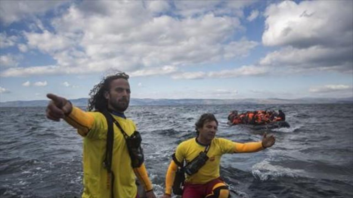 Dos miembros de Proactiva Open Arms socorren a refugiados en el Egeo.-AP / SANTI PALACIOS