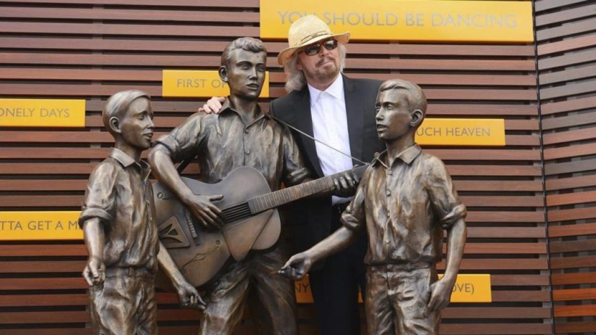 Barry Gibb posa junto a una estatua en honor de Barry Robin y Maurice Gibbs componentes del grupo Bee Gees en la inauguracion oficial del Paseo de lo Bee Gees en en Redcliffe, norte de Brisbane (Australia), en febrero del 2013.-