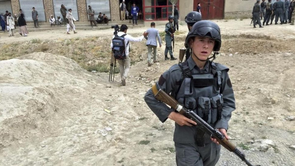 Un policia afgano asegura la zona tras el ataque suicida perpetrado contra un autobus de la policia a las afueras de Kabul.-HEDAYATULLAH AMID