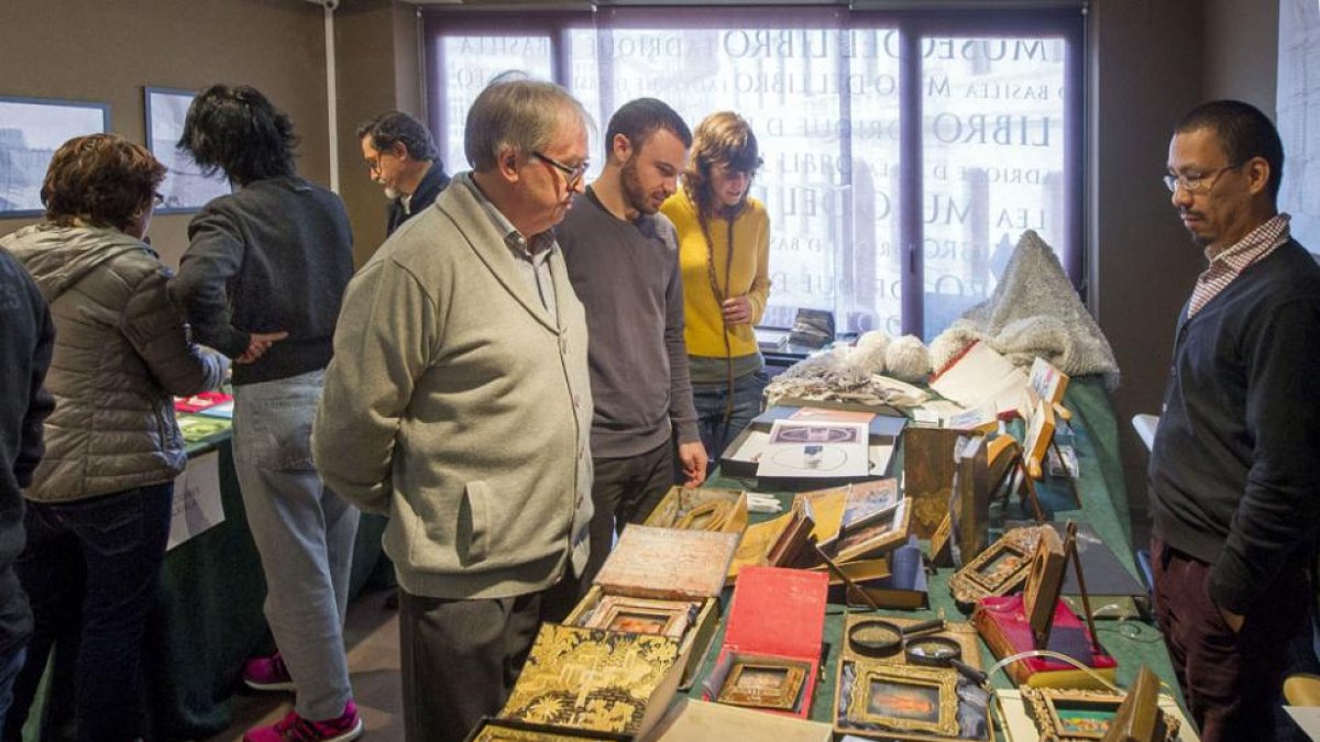 Un grupo de personas observa los ejemplares reunidos para esta cita en el Museo del Libro.-ISRAEL L. MURILLO