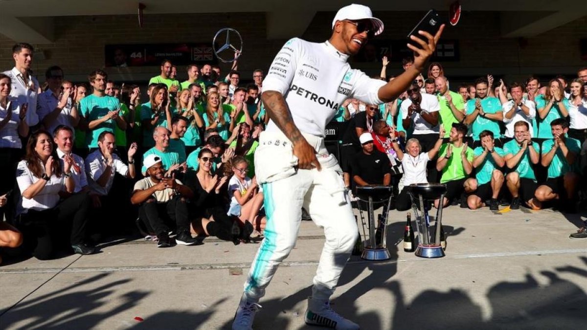 Lewis Hamilton se hace un selfi con su equipo de Mercedes en Austin (EEUU).-AFP / CLIVE ROSE