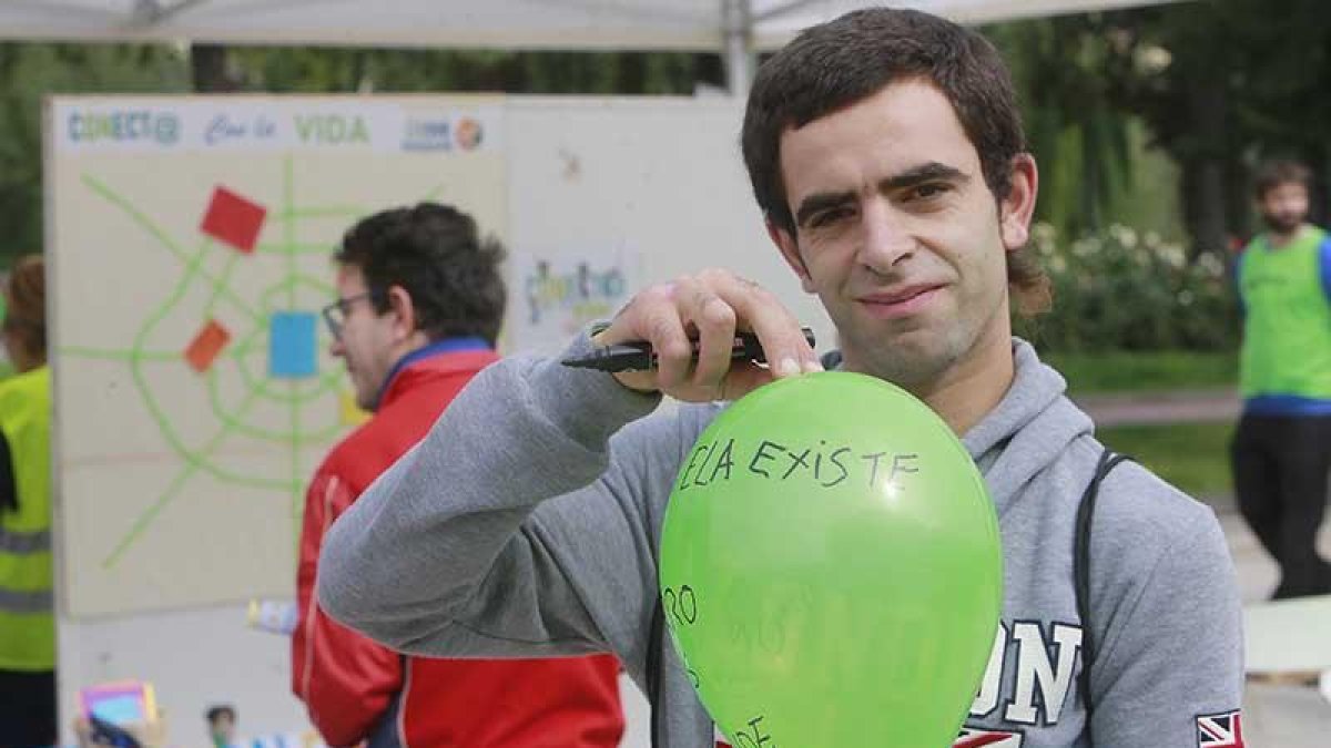 Un paseante posa con un globo que lleva escrito ‘La ELA existe’.-RAÚL G. OCHOA