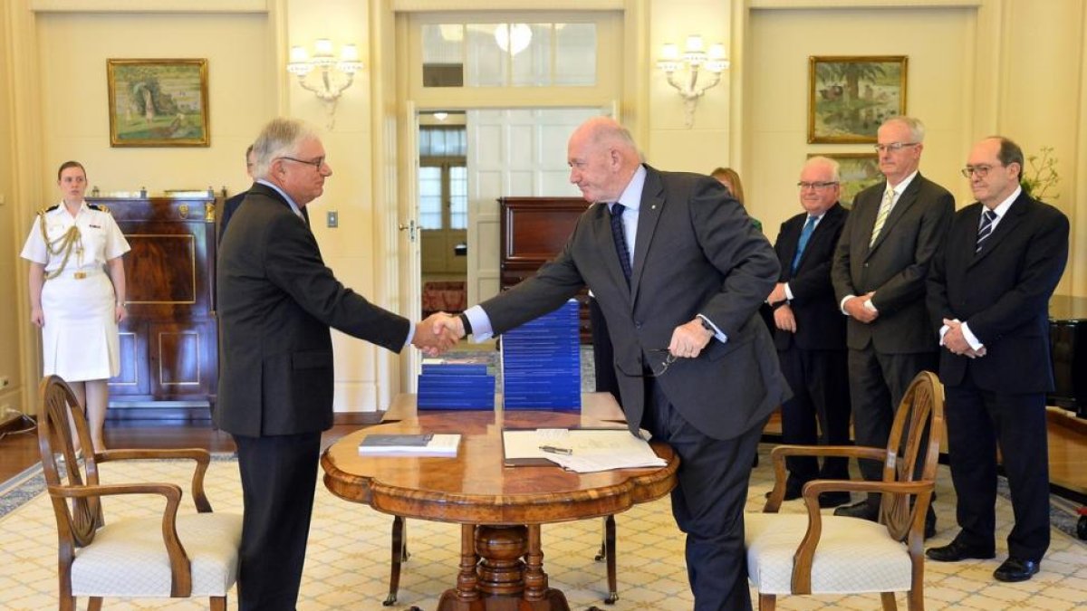 El comisionado de Justicia Peter McClellan (izquierda), y el gobernador general de Australia, Peter Cosgrove, se dan la mano tras la firma del documento final de la comisión especial de la pederastia en Australia.-/ JEREMY PIPER/ROYAL COMMISSION I (EFE)