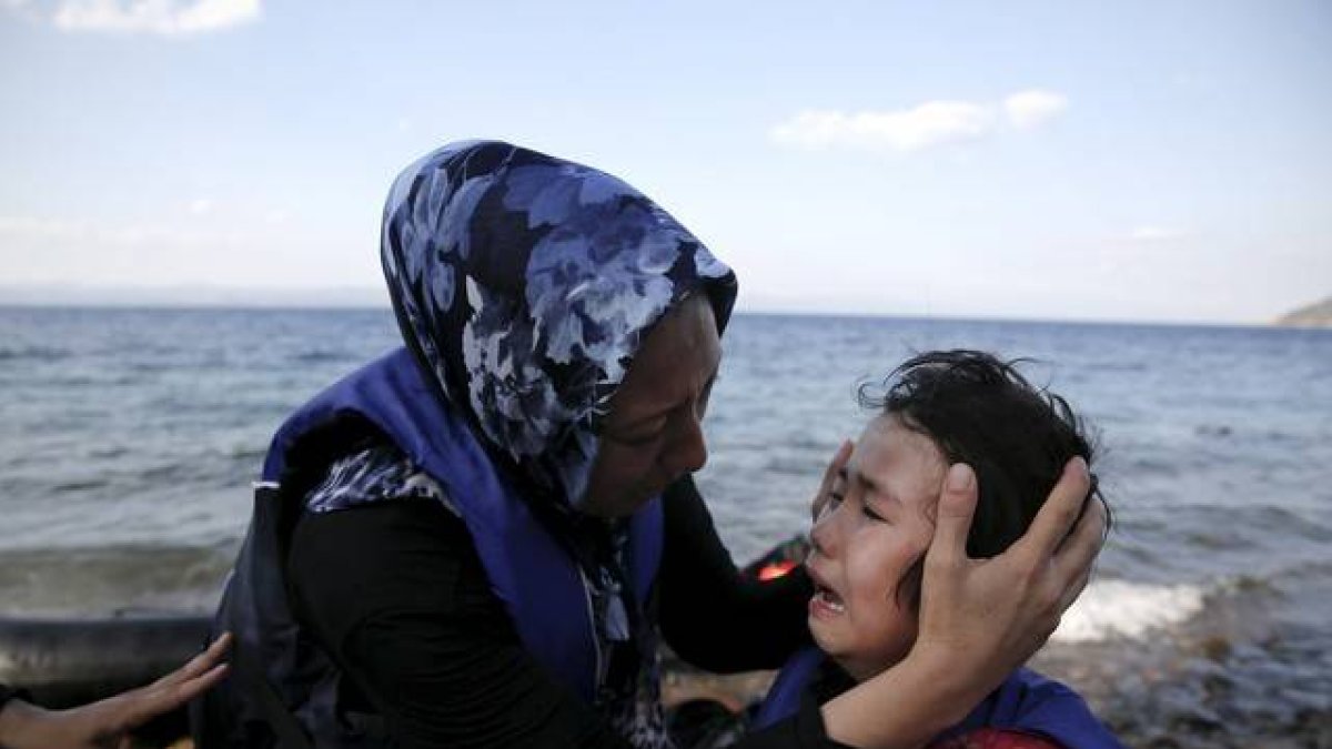Una mujer afgana tranquiliza a su hija, que llora de miedo después de la travesía por mar entre Turquía y Grecia.-Foto: REUTERS / ALKIS KONSTANTINIDIS
