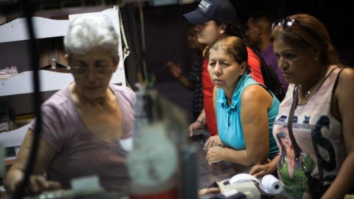 Compras en un mercado de abastos en Caracas.-EFE / CRISTIAN HERNANDEZ