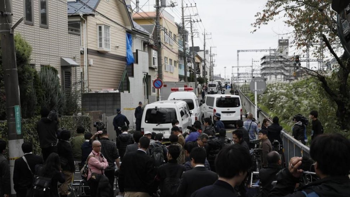 Investigadores policiales vigilan el edificio de apartamentos donde se hallaron los cadáveres descuartizados mientras los periodistas se agolpan en las cercanías, en Zama, el 31 de octubre.-EFE