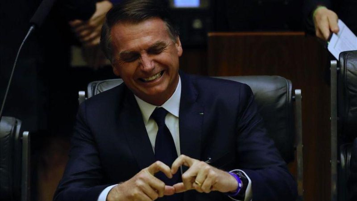 El presidente brasileño, Jair Bolsonaro, muestra un corazón con sus dedos durante su toma de posesión en el Parlamento.-MARCELO CHELLO (EFE)