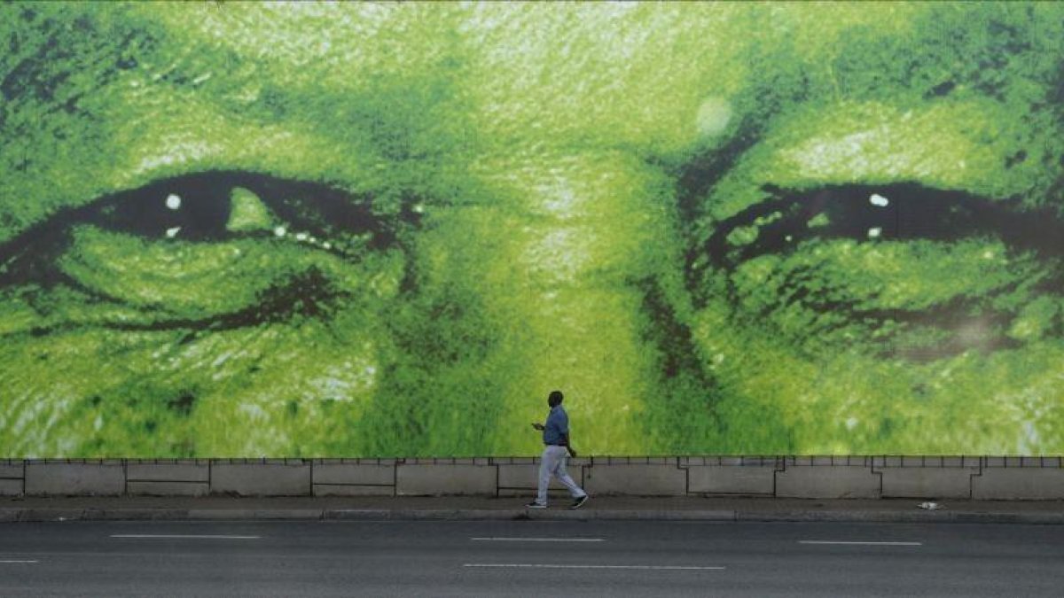 Un hombre pasa en frente de un gigante mural del histórico presidente sudafricano, Nelson Mandela.-AP/ THEMBA HADEBE
