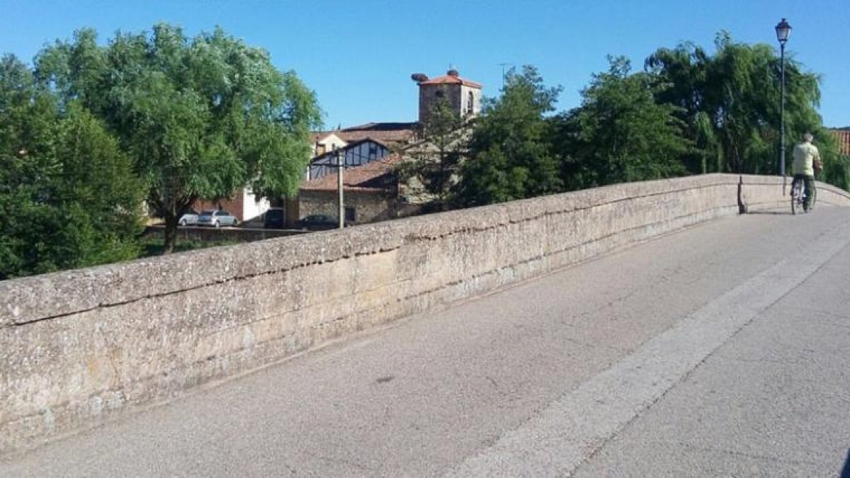 Cruzando el puente de siete ojos sobre el río Arlanza se llega a la localidad.-ECB