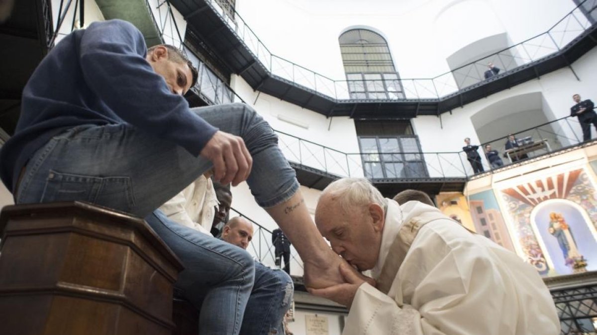El Papa durante el ritual de lavar los pies a uno de los presos de la cárcel Regina Coeli de Roma.-EL PERIÓDICO (AFP)