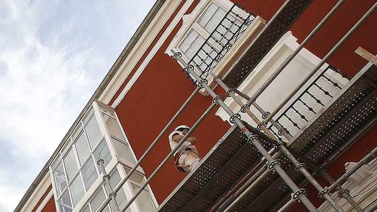 Dos obreros realizan la rehabilitación de una fachada en un edificio de la capital burgalesa.-RAÚL G. OCHOA