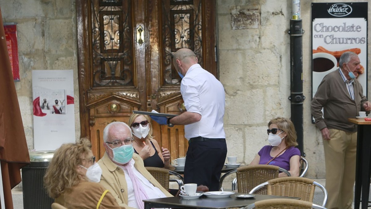 Varias personas en una terraza utilizando correctamente la mascarilla. RAÚL OCHOA