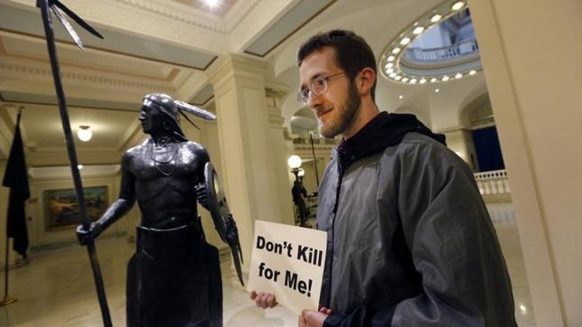 Sam Jennings, de la Coalición de Oklahoma contra la pena de muerte, sostiene un cartel en contra de la pena capital en el Parlamento estatal de Oklahoma, el 29 de abril.-Foto: AP / STEVE GOOCH