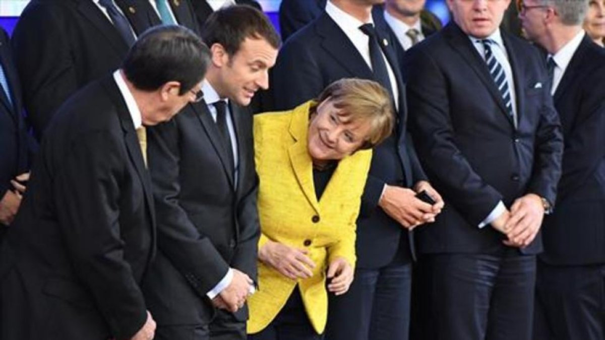 Nicos Anastasiades habla con Angela Merkel, con Emmanuel Macron en medio, en una reciente reunión comunitaria en Bruselas.-/ AFP/EMMANUEL DUNAND