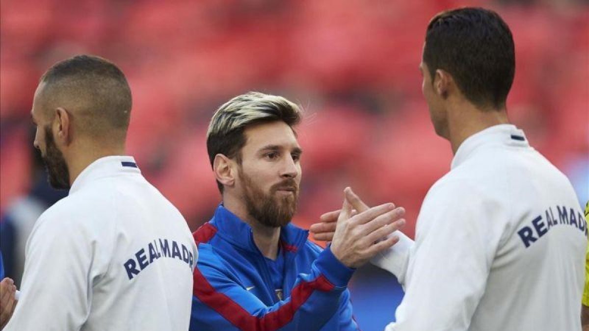 Leo Messi y Cristiano Ronaldo se saludan, en el Camp Nou.-EFE / ALEJANDRO GARCÍA