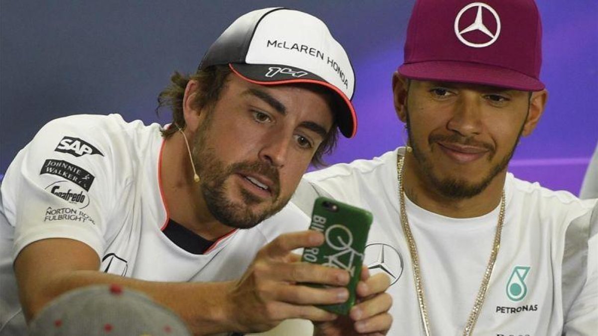 Alonso toma una fotografía con su móvil junto a Hamilton en Montmeló.-AFP / LLUÍS GENE