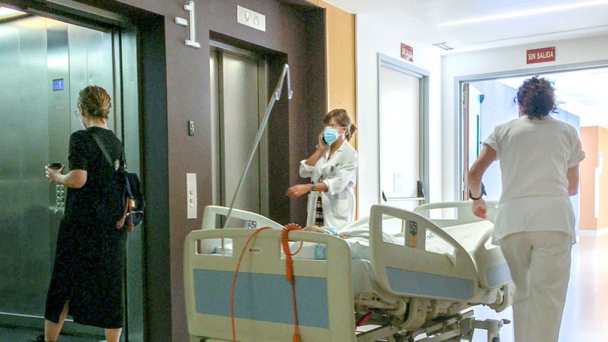Una celadora del HUBU manipula una cama por uno de los pasillos del centro. ISRAEL L. MURILLO