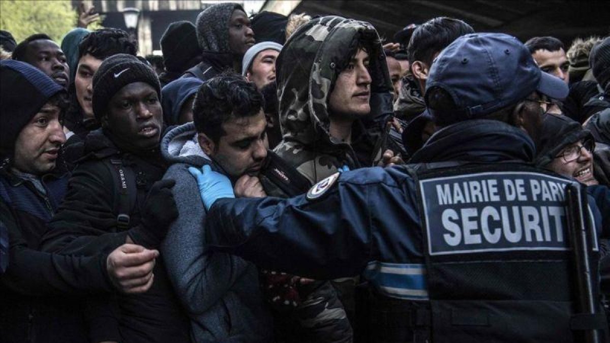 Momentos de tensión durante el desalojo de migrantes y refugiados en un campamento en París.-AFP