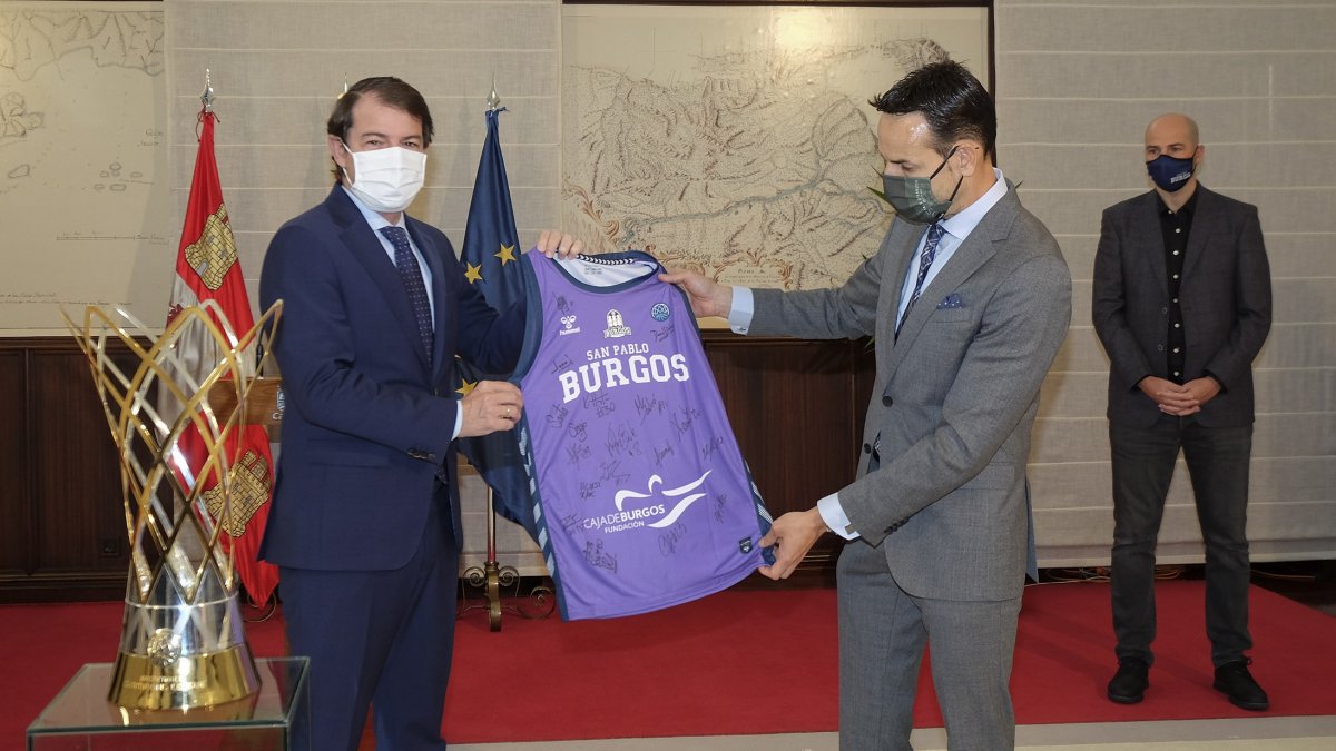 Mañueco, presidente de la Junta de Castilla y León, y Sancho, dirigente del Hereda San Pablo Burgos, posan con la camiseta del club local en el acto protocolario celebrado en Valladolid. JCyL