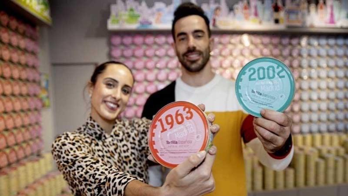 Patricia Álvarez y Guillermo Pérez, en su tienda, posan con dos latas de tortilla de patata.-M.O.M.