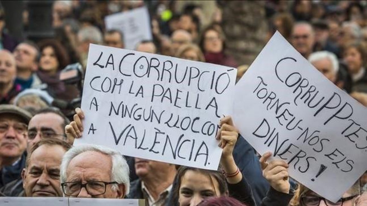 Asistentes a la manifestación contra la corrupción celebrada este domingo en Valencia portan carteles contra el PP y los casos que han afectado a esta comunidad.-MIGUEL LORENZO