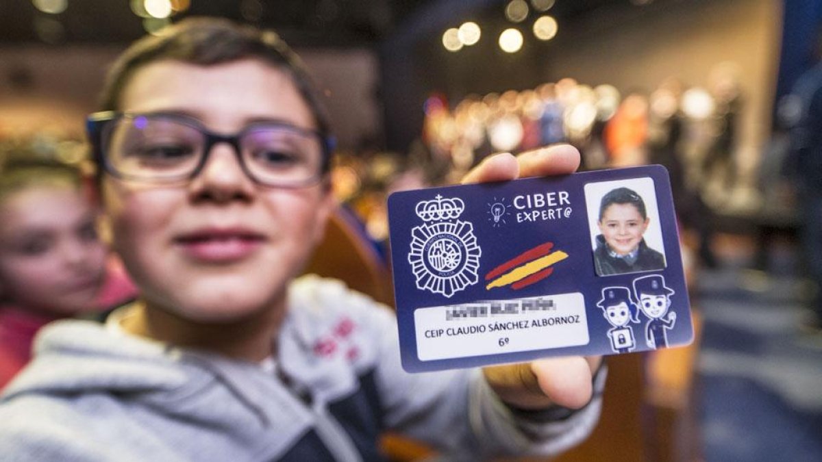 Un alumno muestra orgulloso su recién expendido carné de Ciberexpert@ durante el acto de entrega, ayer, en la Casa de Cultura de Gamonal.-ISRAEL L. MURILLO