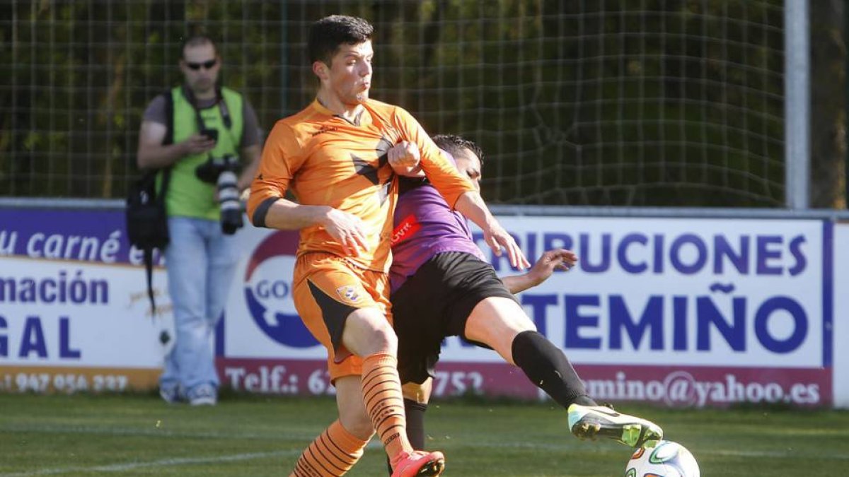 Manzano forcejea con un defensor del CD Palencia en el duelo de ayer en Castañare-Raúl G. Ochoa