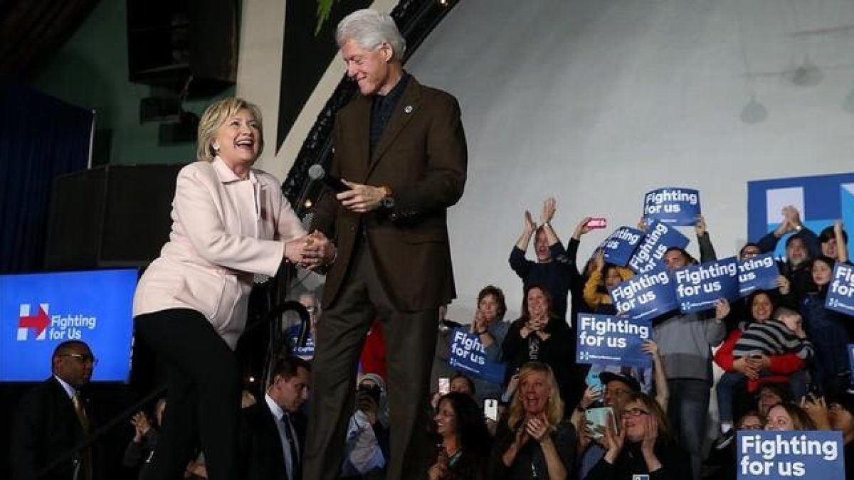 La candidata demócrata Hillary Clinton junto a su marido, expresidente de EEUU, en el caucus en Davenport (Iowa).-AFP / JUSTIN SULLIVAN