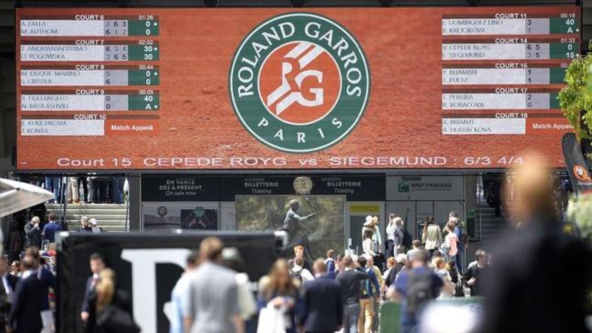 El público pasea por los alrededores de la pista Suzanne Lenglen mientras se disputan partidos de la roda previa de Roland Garros, este jueves.-Foto: AFP / MIGUEL MEDINA