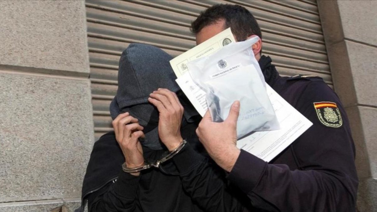 Un detenido y un policía en la anterior redada de amaño de partidos, en Murcia el pasado mes de febrero.-/ MARCIAL GUILLEN