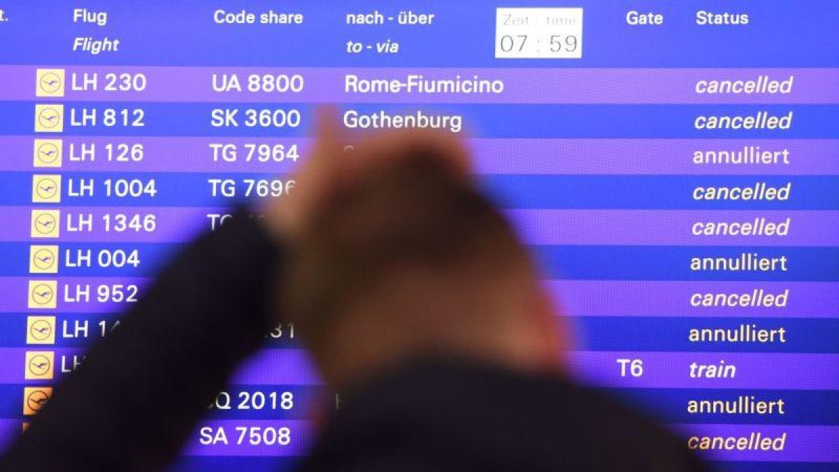 Un hombre ante la información de vuelos cancelados.-ARNE DEDERT (AFP)
